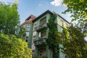 Un bâtiment vert avec du lierre sur lui dans l'établissement Schloss - Apartments an der Uni - Klinik, à Dresde