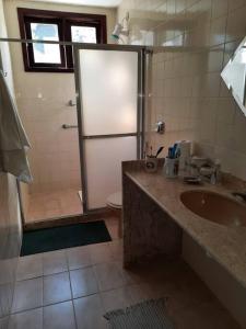 a bathroom with a shower and a sink and a toilet at Praia Itacoatiara Casa Jardim in Niterói
