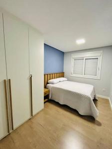 a bedroom with a large bed and a window at Apartamento em Bento Gonçalves in Bento Gonçalves
