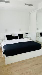 a white bedroom with a black and white bed at Villa Siena, in the center of Playa del Ingles, close to CC Jumbo in Maspalomas