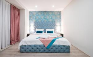 sypialnia z niebieskim łóżkiem z niebieskim zagłówkiem w obiekcie Capitol Hotel By umbrella w mieście Tbilisi City