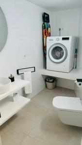 een badkamer met een wasmachine en een toilet bij Villa Siena, in the center of Playa del Ingles, close to CC Jumbo in Maspalomas