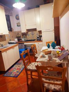 a kitchen with white cabinets and a table and chairs at B&B Mannalà in Agrigento