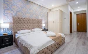 1 dormitorio con 1 cama grande y pared azul en Capitol Hotel By umbrella, en Tiflis