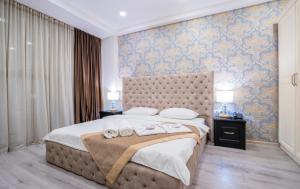 una camera da letto con un grande letto con asciugamani di Capitol Hotel By umbrella a Tbilisi City