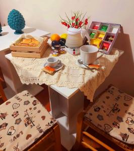 a table with two chairs and a table with food on it at B&B Mannalà in Agrigento +5 photos