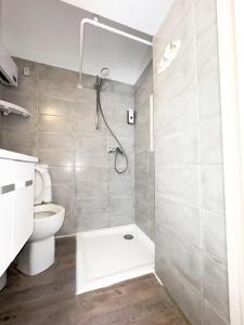 uma casa de banho com um chuveiro e um WC. em Bégonias Appartement T3 Avenue de Lodève em Montpellier