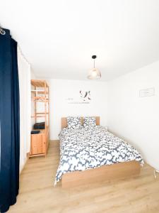 um quarto com uma cama num quarto branco em Bégonias Appartement T3 Avenue de Lodève em Montpellier
