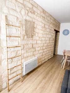 uma sala de estar com uma parede de tijolos e uma escada em Bégonias Appartement T3 Avenue de Lodève em Montpellier