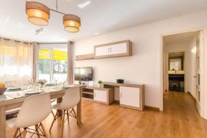 eine Küche mit weißen Wänden und einem Tisch und Stühlen in der Unterkunft Apto Park Lein, 5 huéspedes muy cerca de la playa in Lloret de Mar