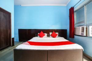 um quarto com uma cama grande e almofadas vermelhas em OYO 67226 Om Hotel em Neemrana