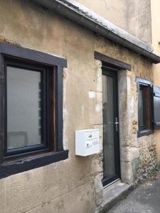 un edificio con ventana y ventana con vistas en Double gite, Duplex et Chaleureuse petite maison, en Beaumont-sur-Sarthe