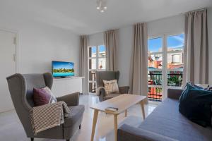 uma sala de estar com um sofá e cadeiras e uma televisão em Easy apartment in Fuengirola Downtown - Ref 28 em Fuengirola