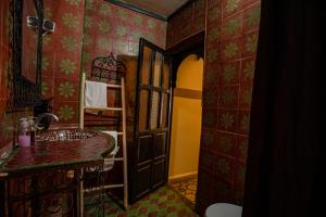 W pokoju z czerwonymi ścianami znajduje się łazienka z umywalką. w obiekcie Riad Arabesque w Marakeszu