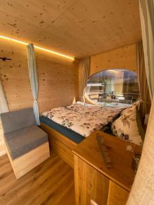 1 dormitorio en una cabaña de madera con cama y banco en Unique Tiny Eco Lodges with gorgeous views to Jungfrau Massiv en Interlaken