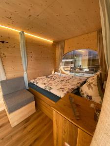 インターラーケンにあるUnique Tiny Eco Lodges with gorgeous views to Jungfrau Massivのログキャビン内のベッドルーム(ベッド1台、ベンチ付)