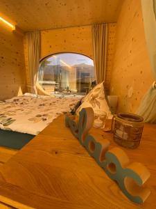 インターラーケンにあるUnique Tiny Eco Lodges with gorgeous views to Jungfrau Massivの大きな窓付きの客室の木製ベッド1台分です。
