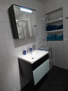 a white bathroom with a sink and a mirror at Ferienwohnung Astl in Kirchdorf in Tirol