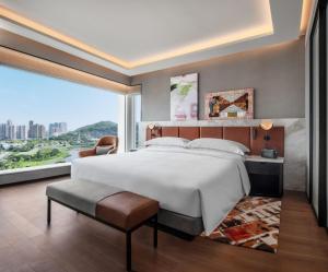 a bedroom with a large bed and a large window at Andaz Macau in Macau