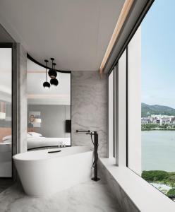 baño con bañera y ventana grande en Andaz Macau en Macao