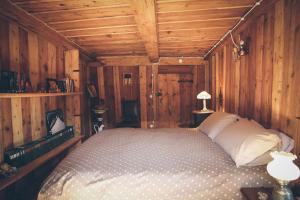 1 dormitorio con 1 cama en una habitación de madera en La Taverna dei Due Gufi, en Saint-Rhémy-en-Bosses