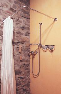 y baño con ducha y pared de piedra. en La Taverna dei Due Gufi, en Saint-Rhémy-en-Bosses