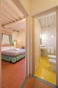 a bedroom with a bed and a bathroom with a sink at Casamaggio in San Donato in Collina