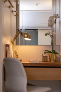 einen Schreibtisch mit einem Stuhl, einer Lampe und Blumen in der Unterkunft The Luxury Inn in London