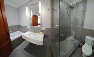 a bathroom with a sink and a shower and a toilet at Villa Tuscana in Port Elizabeth