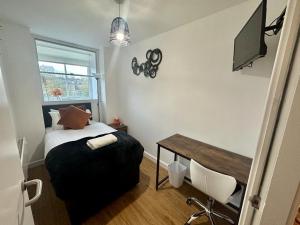 a bedroom with a bed and a desk and a window at Chamber Apart City Centre BD1 in Bradford
