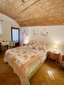 sypialnia z łóżkiem i ceglaną ścianą w obiekcie Grotto Flora B&B Chambres de charme w mieście Bigogno