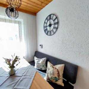ein Schlafzimmer mit einem Bett und einer Uhr an der Wand in der Unterkunft Ferienwohnung Lichtenauer Hof in Thyrnau