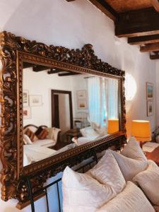 un soggiorno con specchio decorato sopra un divano di Grotto Flora B&B Chambres de charme a Bigogno