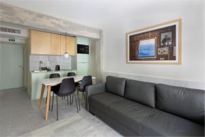 a living room with a couch and a table and a kitchen at Mooeve Exarchia in Athens