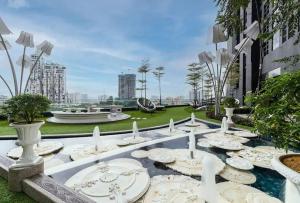 a table with white plates and candles in a park at Arte Mont Kiara Cozy 1BR Suites in Kuala Lumpur