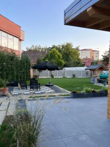 a patio with two benches and an umbrella at Verte House in Alba Iulia