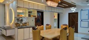 uma sala de jantar com uma mesa de madeira e cadeiras em Luxurious 3-bhk highly secured & close to airport em Daca