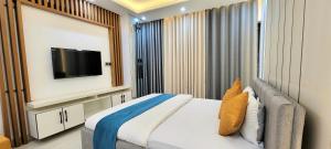 um quarto com uma cama grande e uma televisão em Luxurious 3-bhk highly secured & close to airport em Daca