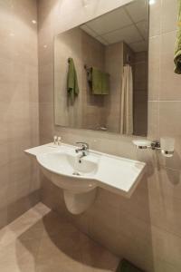 W łazience znajduje się biała umywalka i lustro. w obiekcie Kalithea Family Hotel w mieście Sozopol