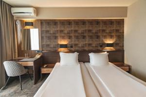 - une chambre avec un grand lit, un bureau et deux oreillers dans l'établissement Kalithea Family Hotel, à Sozopol