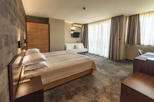 ソゾポルにあるKalithea Family Hotelの大きなベッドとソファが備わるホテルルームです。