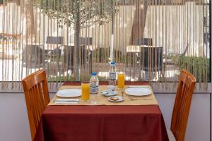 a table with plates and glasses of orange juice at Primavera 2 Hotel in Pazardzhik