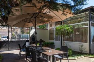 a restaurant with tables and chairs under an umbrella at Primavera 2 Hotel in Pazardzhik