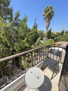 einen Balkon mit einem Tisch und einem Stuhl in der Unterkunft Aphrodite's gardens in Paphos City
