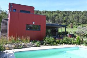 a red house with a swimming pool in front of it at nature in Gardanne