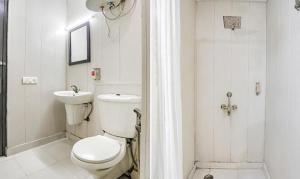 a white bathroom with a toilet and a sink at FabHotel F9 Sector 51 in Noida