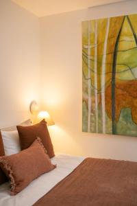 The Luxury Inn في لندن: غرفة نوم بسرير مع لوحة على الحائط