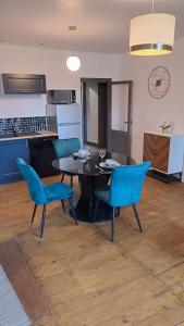 ein Esszimmer mit einem Tisch und blauen Stühlen in der Unterkunft Chez germaine in Murat