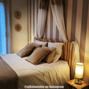 a bed with pillows on it in a bedroom at Villa Font Vive - Chambres d'hôtes éco-labellisées avec cuisine - Confort, calme et vue exceptionnels ! in Grospierres