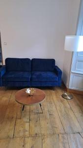ein Wohnzimmer mit einem blauen Sofa und einem Tisch in der Unterkunft Chez germaine in Murat